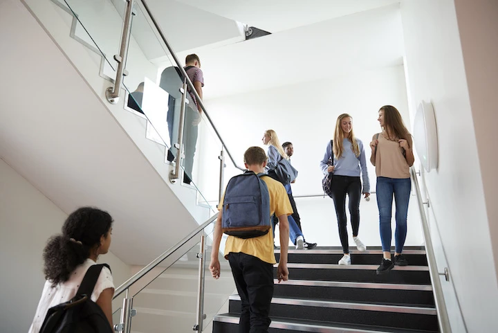Students Walking On Stairs Between Lessons In Busy University Building
