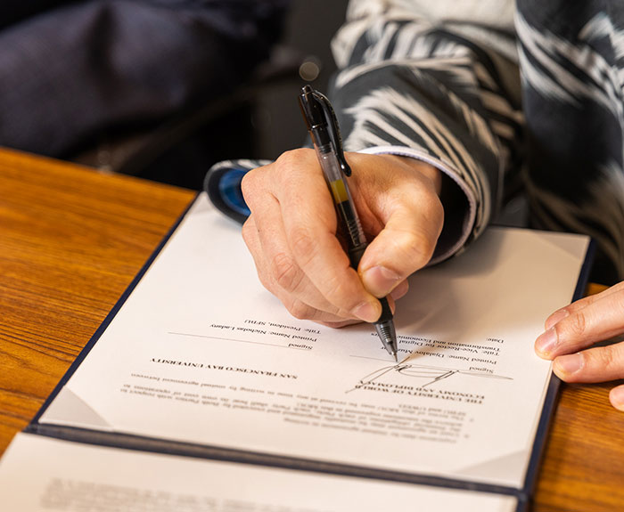 Close up of a hand signing a document.