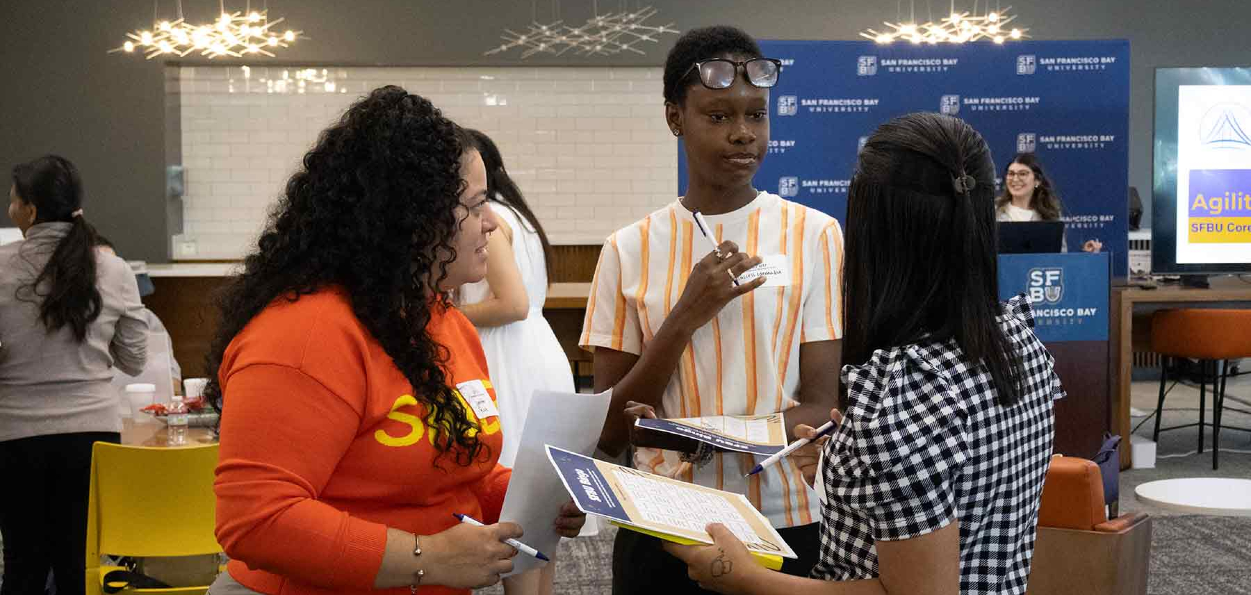 Three female students standing having a discsussion