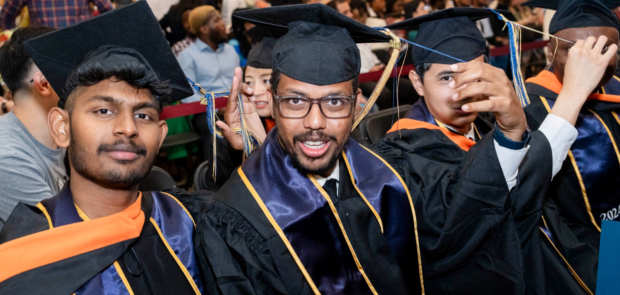 Happy students in their cap and gown graduating.