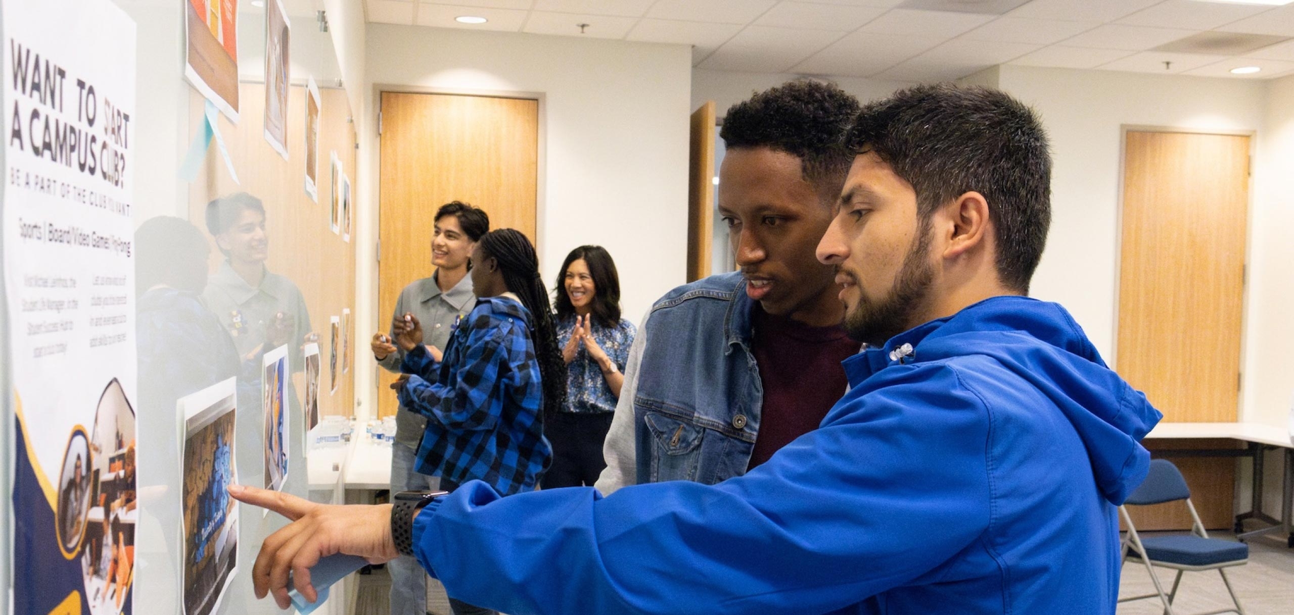 Two students looking at an infographic on a white board