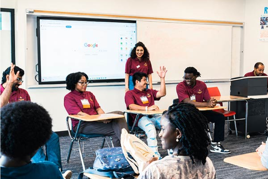 Students in a classroom raising their hand
