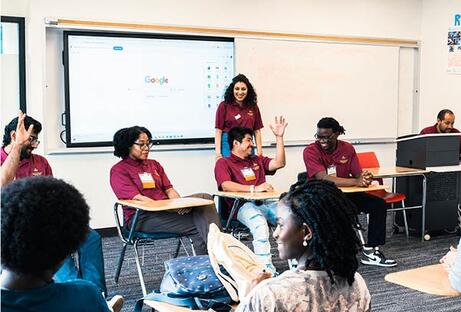 Students in a classroom raising their hand