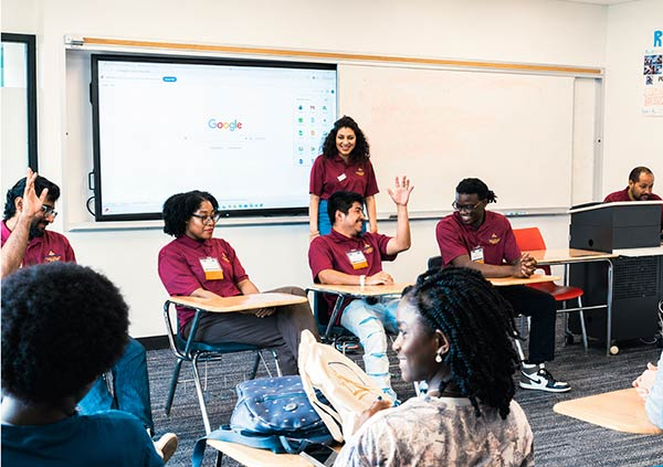 Students in a classroom raising their hand
