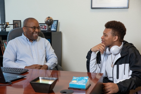 Dr. Peter Maribei is talking with a student in the Student Success Hub