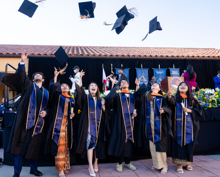 SFBU Graduates tossing their caps in celebration