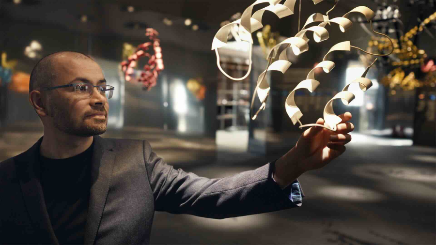 Image directly from film of founder Demis Hassabis inspecting a 3D artwork